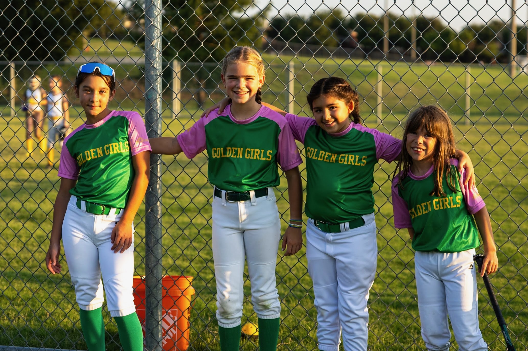Golden Girls softball teammates leaning on the fence