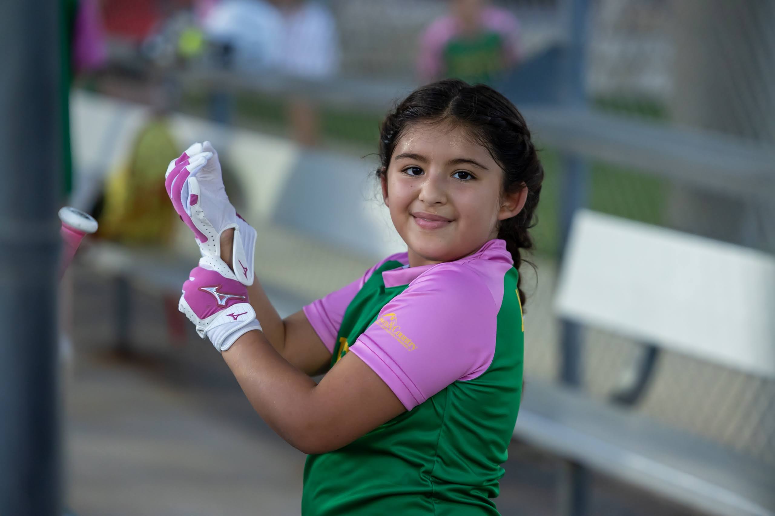 Softball player putting on her batting gloves