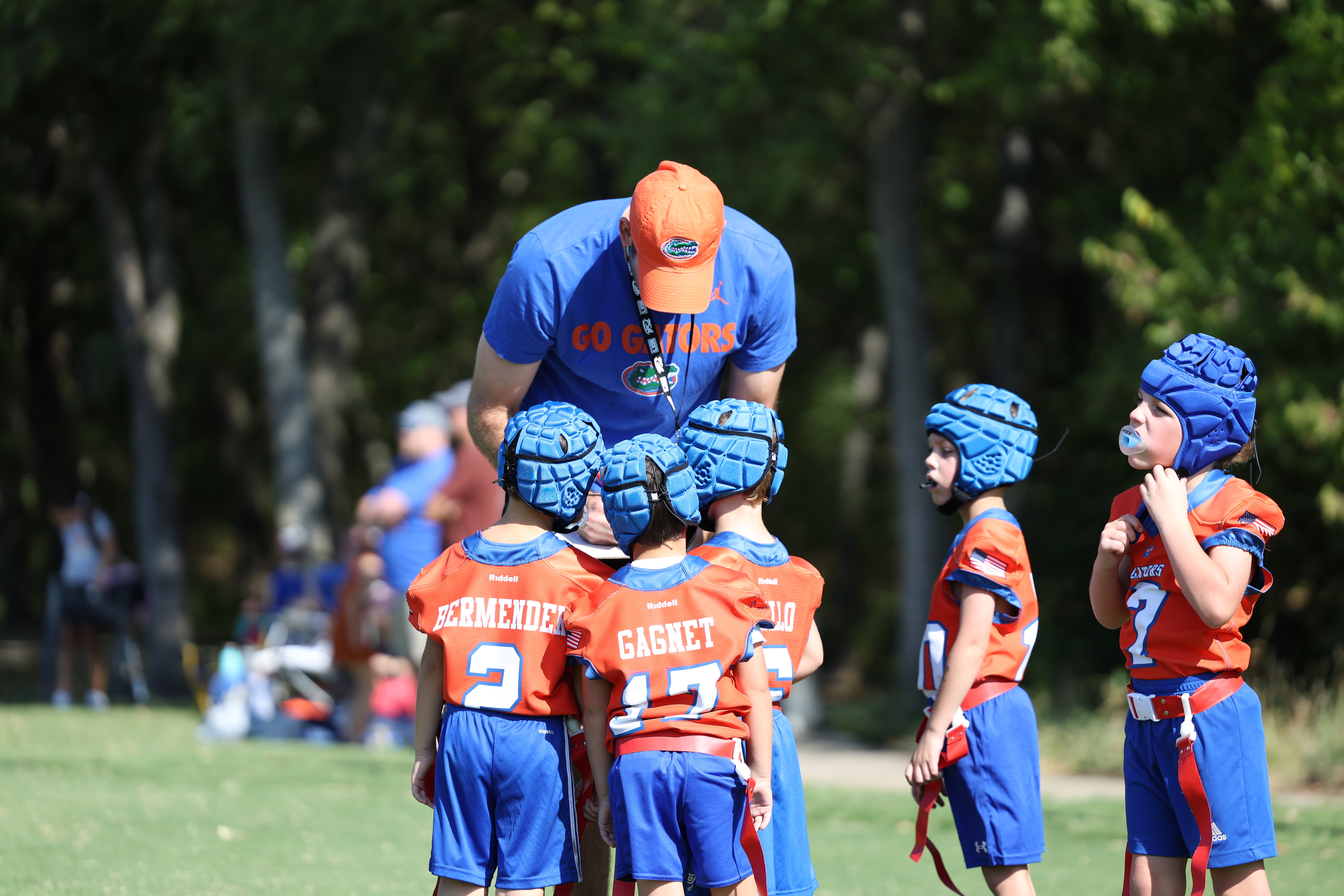 Coach huddled with his youth football team