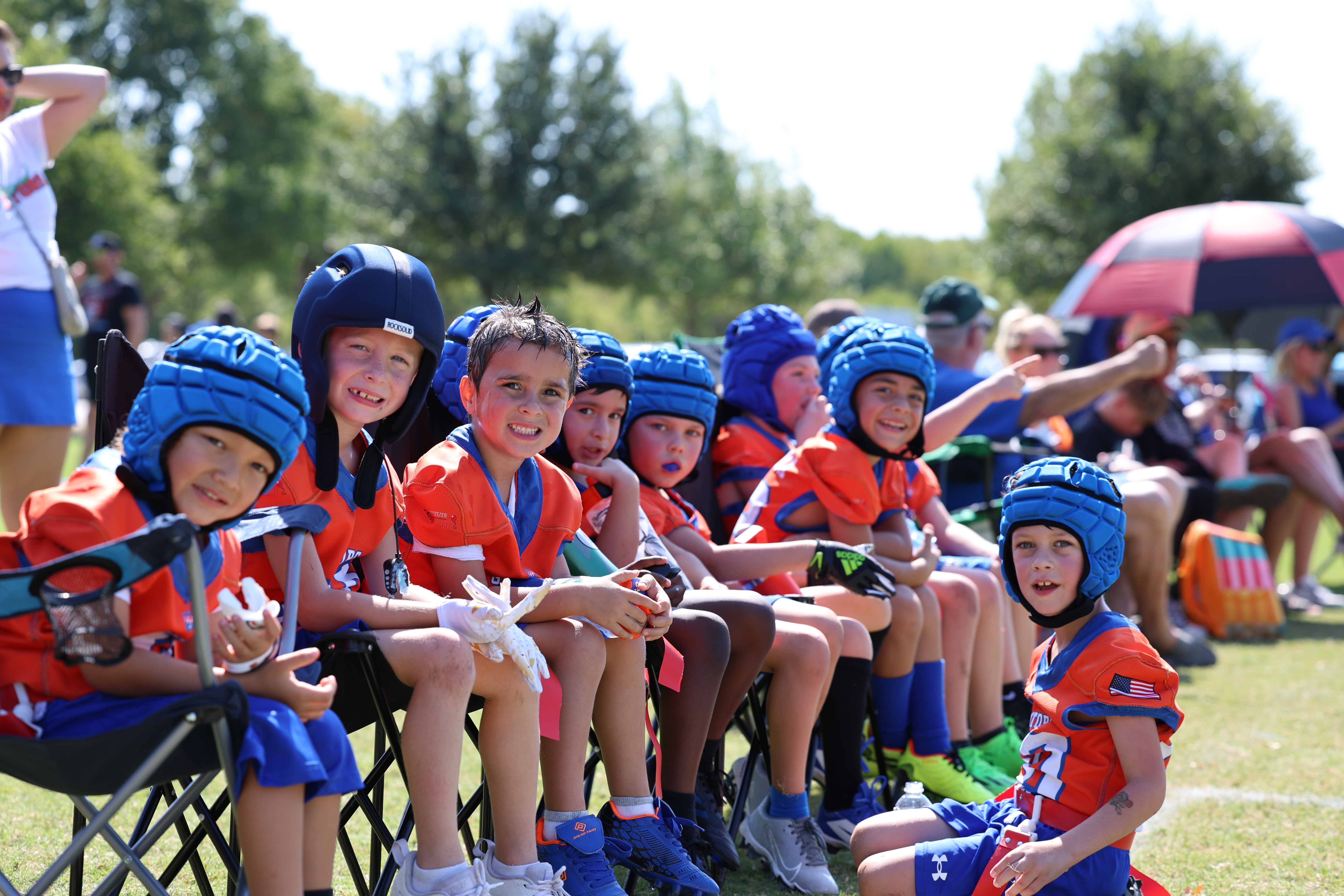 Flag football team on the bench in matching helmets