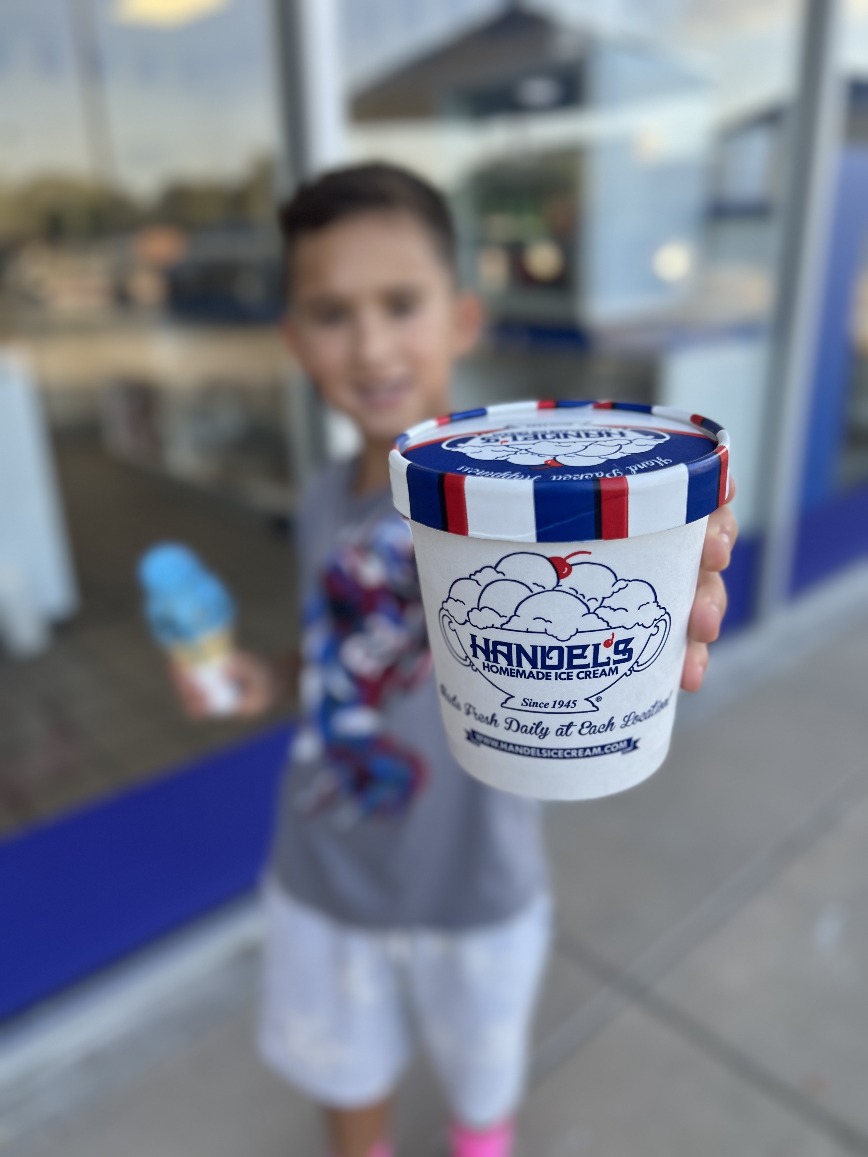 Kid holding an ice cream cup from a local small business